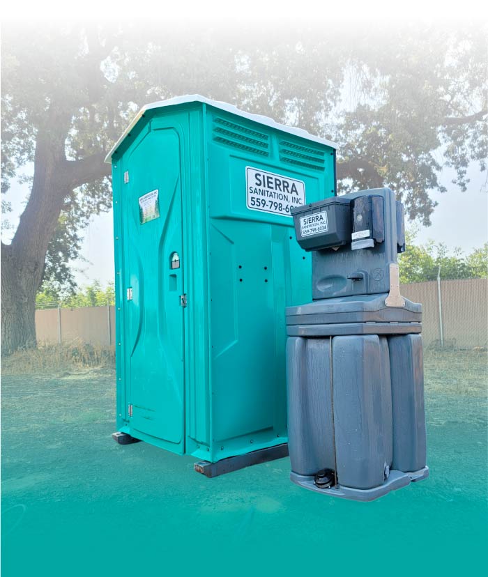 Standard portable toilet and freestanding handwash station side-by-side on a construction site in Visalia, CA, provided by Sierra Sanitation Inc