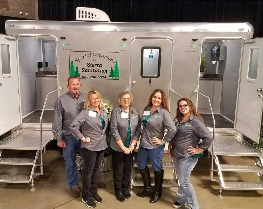 team-of-sierra-sanitation-inc sierra sanitation team in front of a well-maintained vip porta potty ready for rental